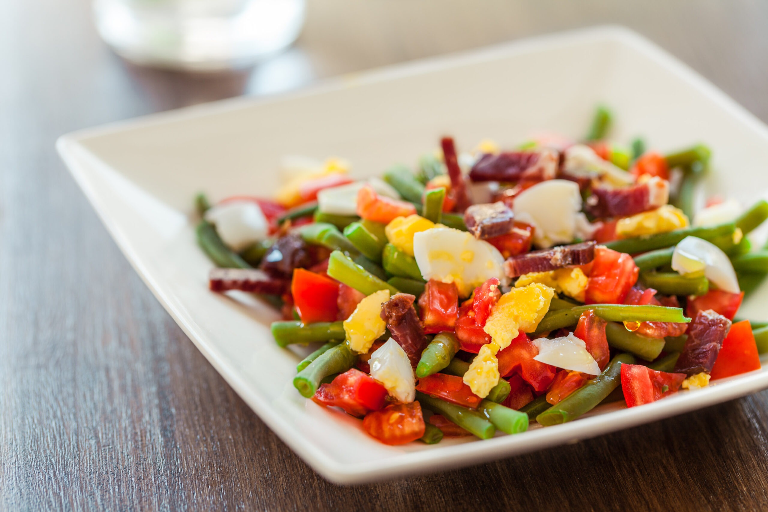 Judías verdes con tomate, huevo duro y jamón, plato saludable y equilibrado rico en proteínas y nutrientes esenciales.