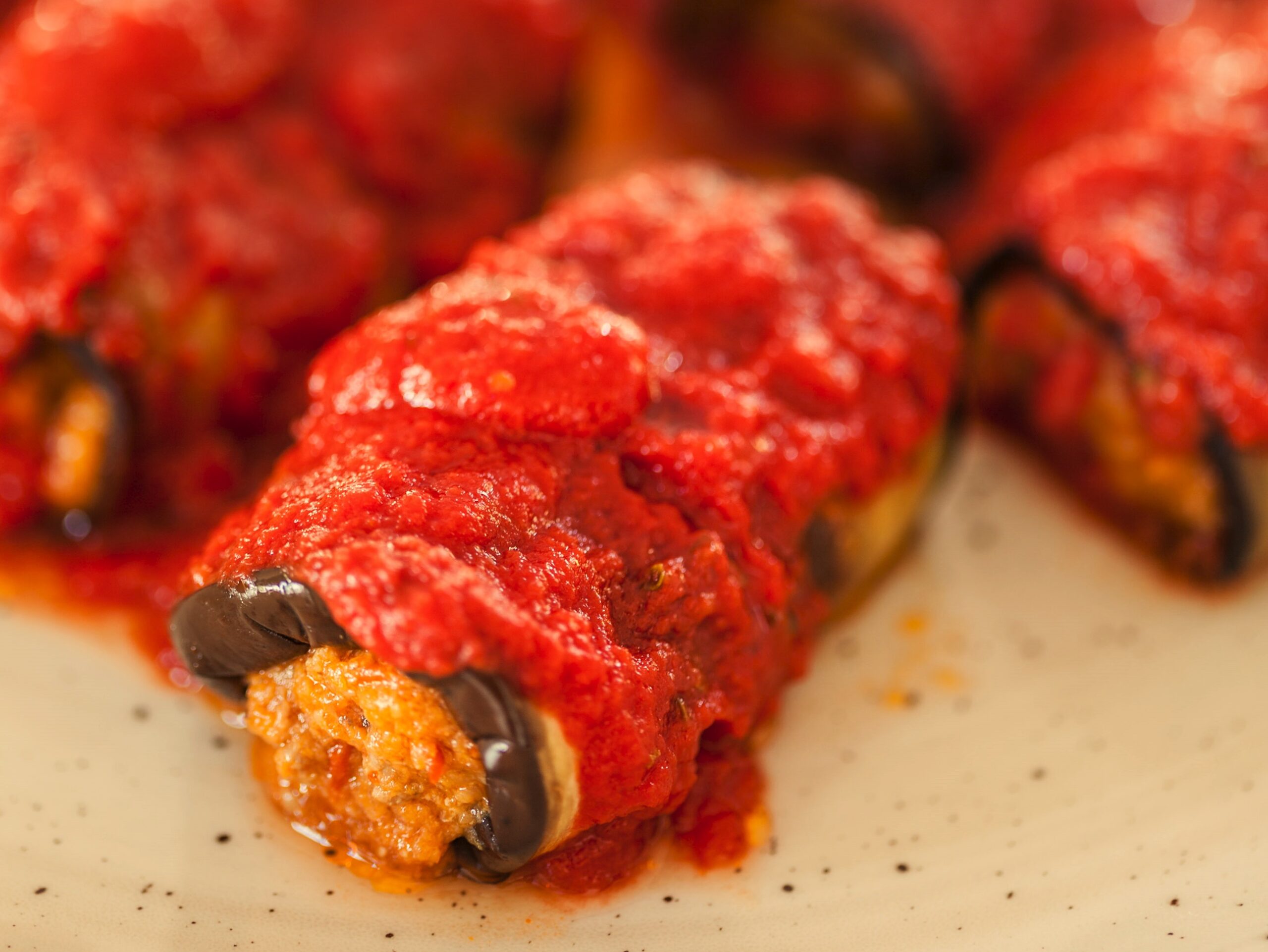 Rollitos de berenjena rellenos con salsa de tomate, receta saludable rica en verduras, ideal para una alimentación equilibrada y nutritiva.