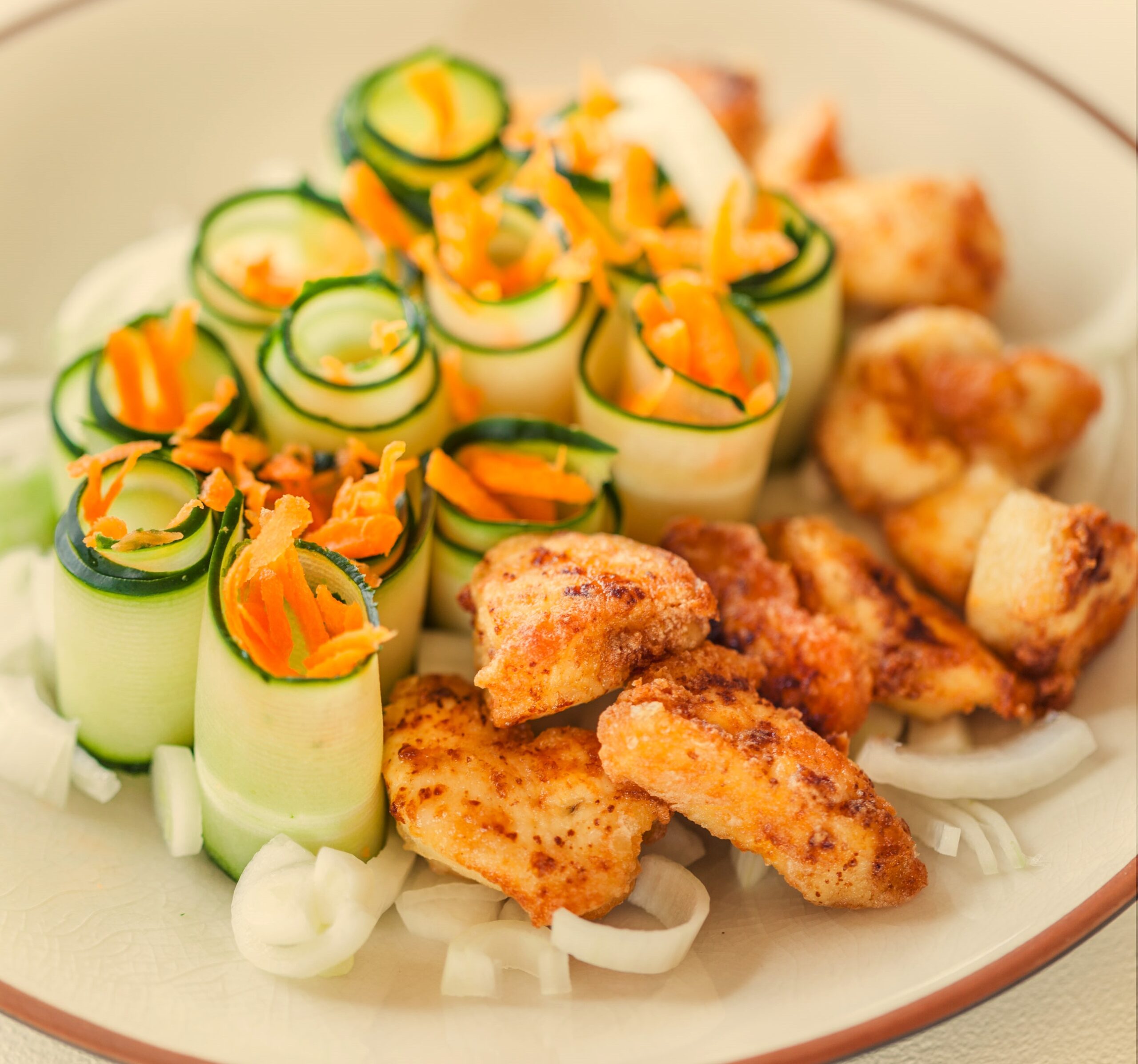 Ensalada de pollo crujiente con jengibre y vegetales frescos, plato ligero y equilibrado con contraste de texturas y toque aromático.