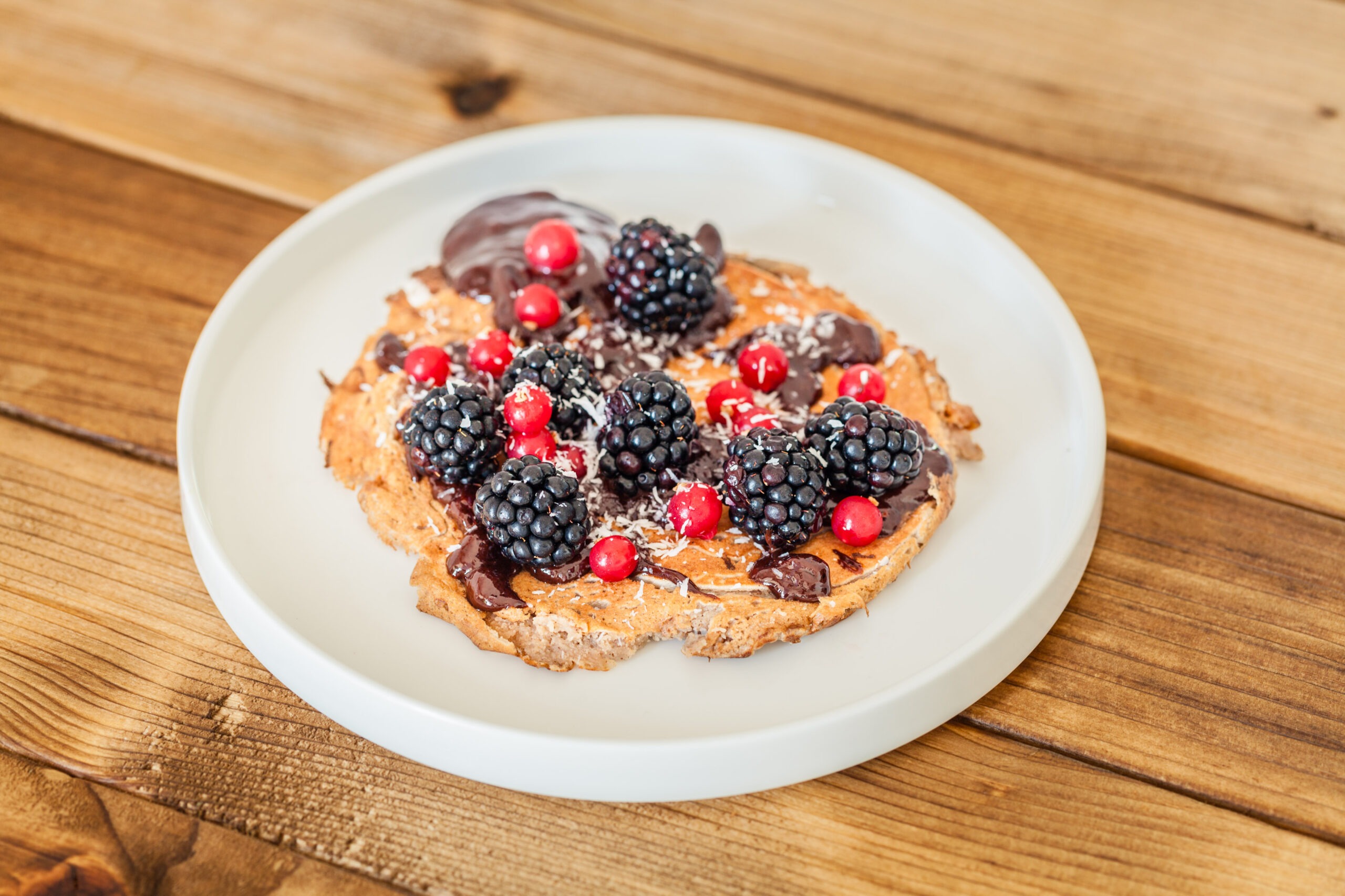 Tortitas con frutos rojos y chocolate, desayuno dulce y nutritivo con contraste de sabores y aporte antioxidante.